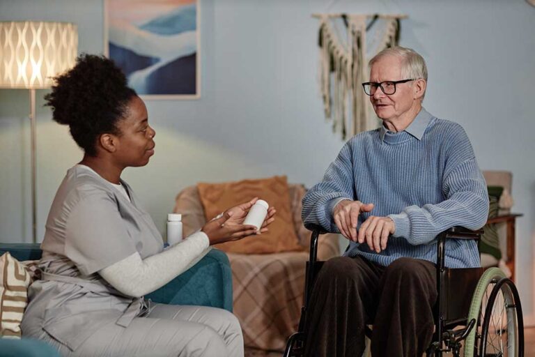 Two older adults and a family member looking at a laptop together at a kitchen table, reviewing senior living options.